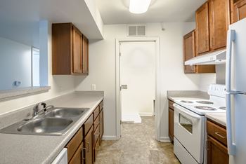 A kitchen with a white door and a white stove.